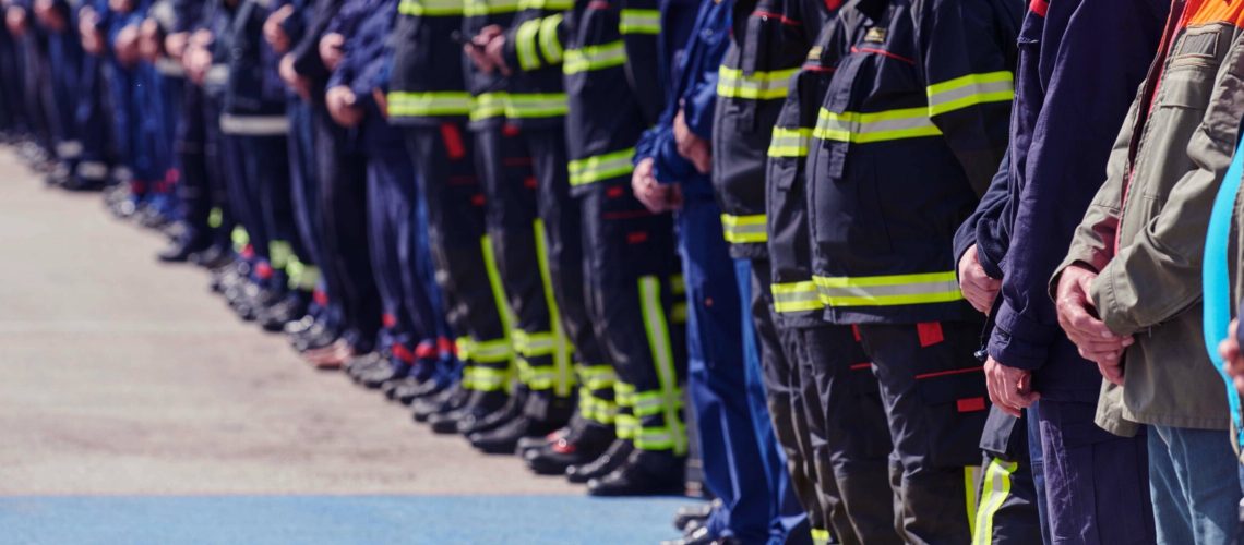 A group of firefighters lined up, saluting the flag, applauding in solidarity, and gearing up for intensive training sessions, showcasing their unwavering commitment to service and teamwork